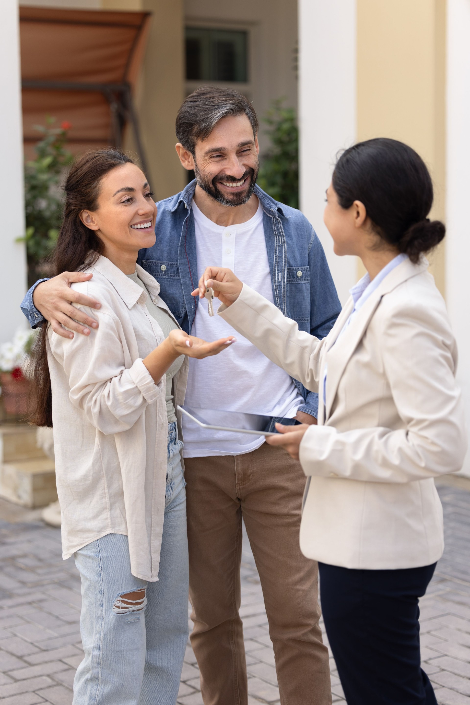 Happy Latin family couple getting new home, taking key